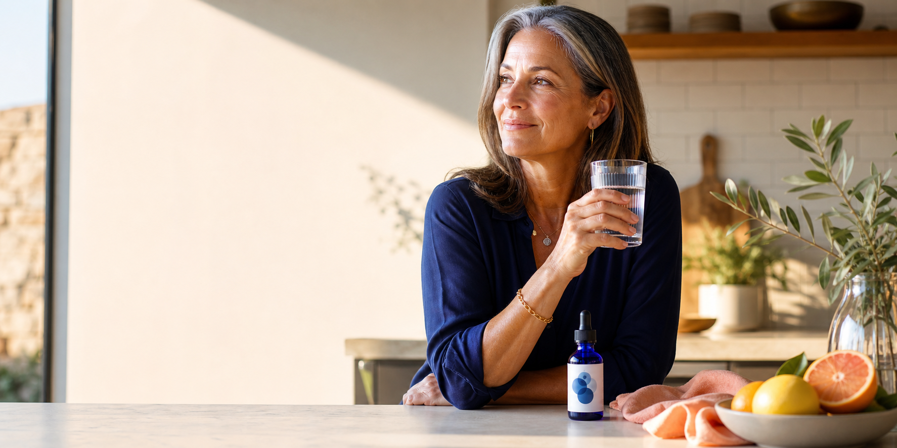 Woman enjoying a bright morning ritual beside a cobalt dropper bottle